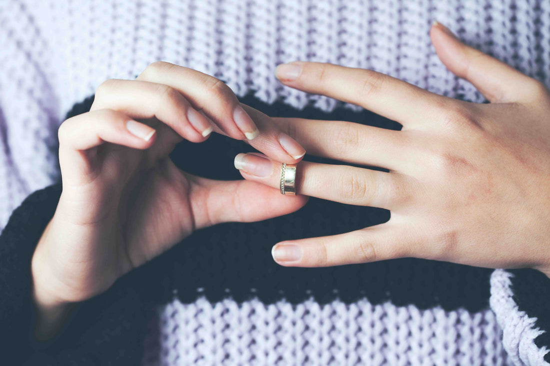 A woman removing a gold ring with ease.