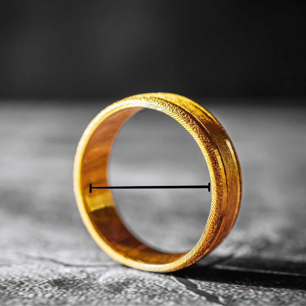 Gold ring with intricate design on a textured surface