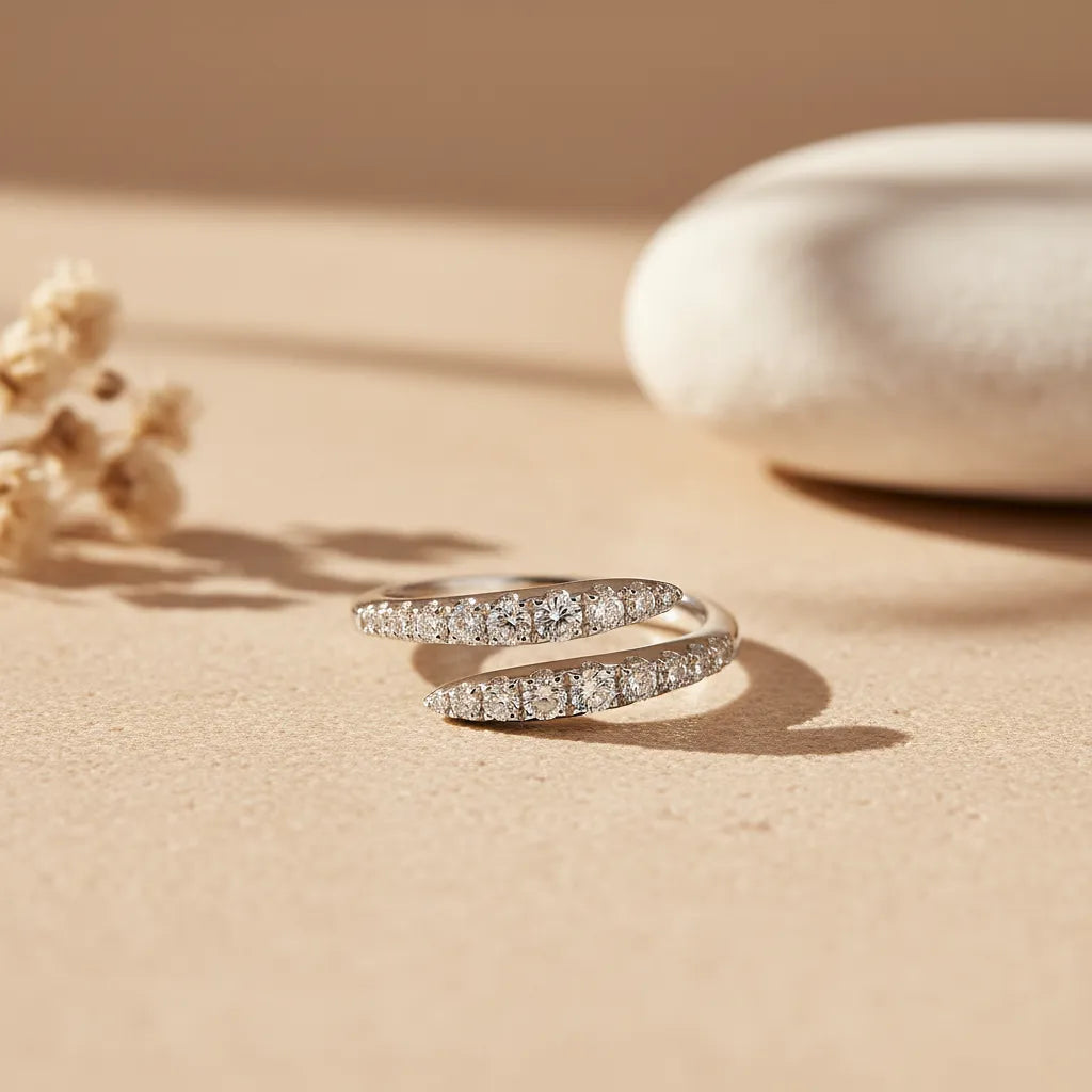 Moissanite ring on a sandy surface with a stone and dried flowers in the background